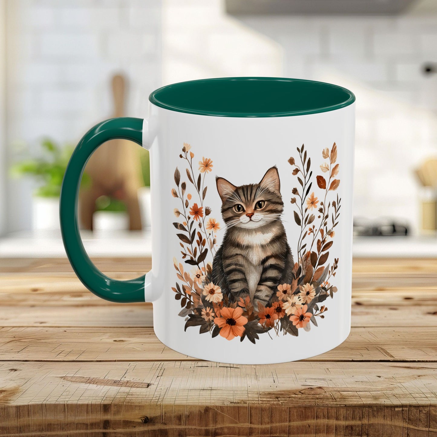 White ceramic mug with a tabby kitten and autumnal wildflowers, featuring a dark green handle and interior.