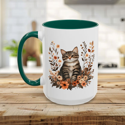 White ceramic mug with a tabby cat and autumnal wildflowers, featuring a dark green handle and interior.