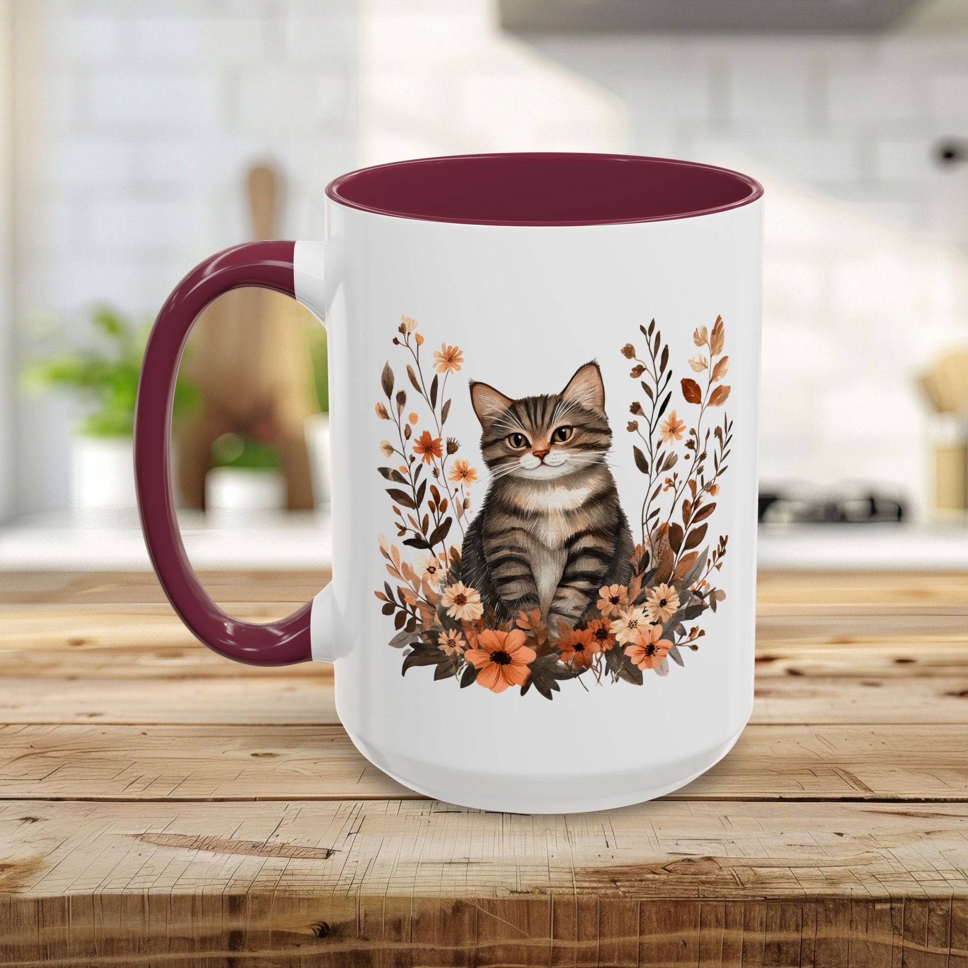 White ceramic mug with a tabby cat among autumn wildflowers, burgundy interior and C-handle.