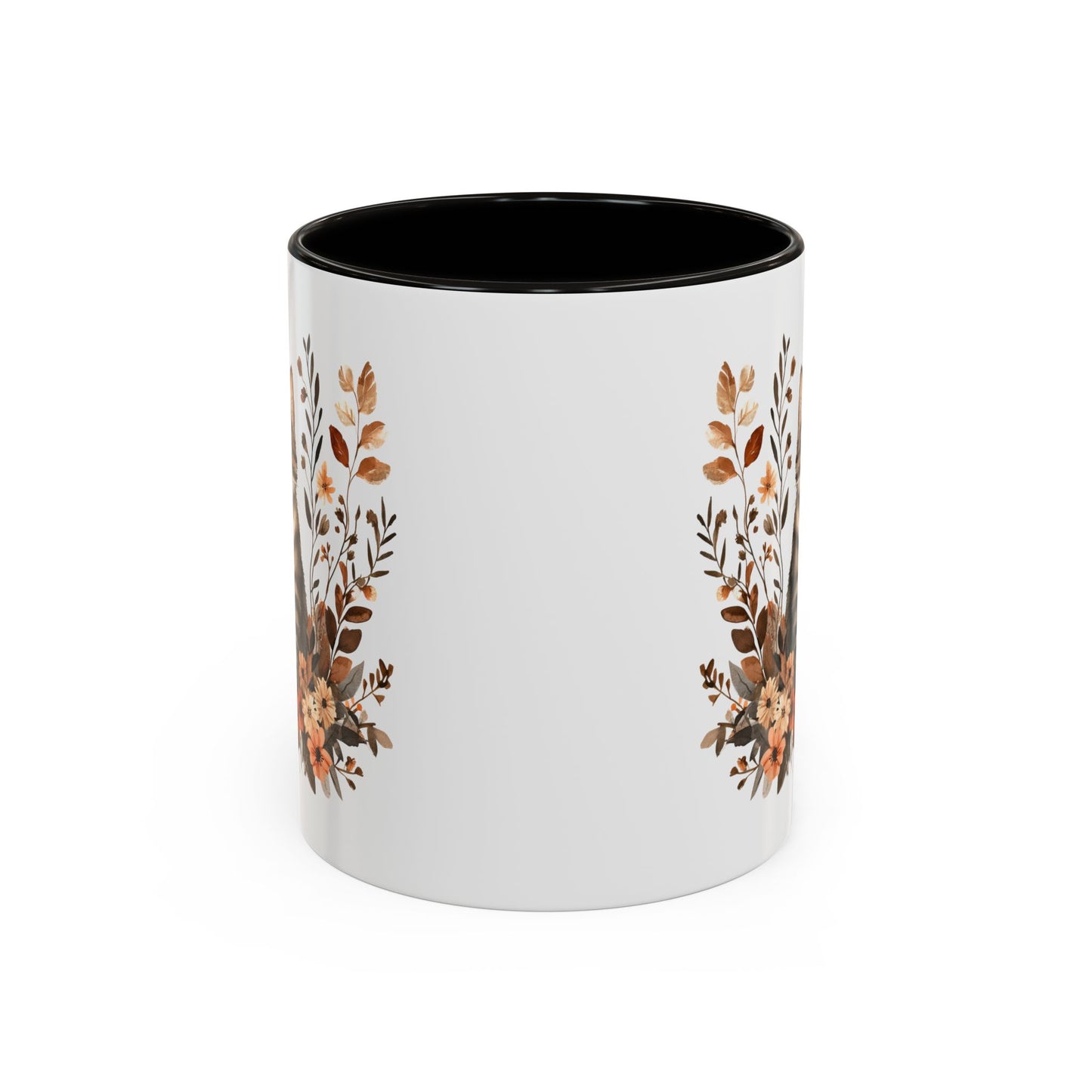 White ceramic mug with black interior and handle, featuring autumnal floral designs on the sides.