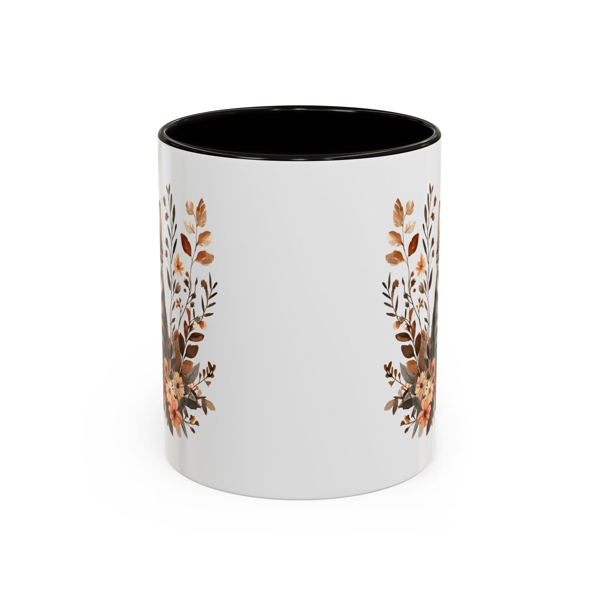White ceramic mug with black interior and handle, featuring autumnal floral designs on the sides.