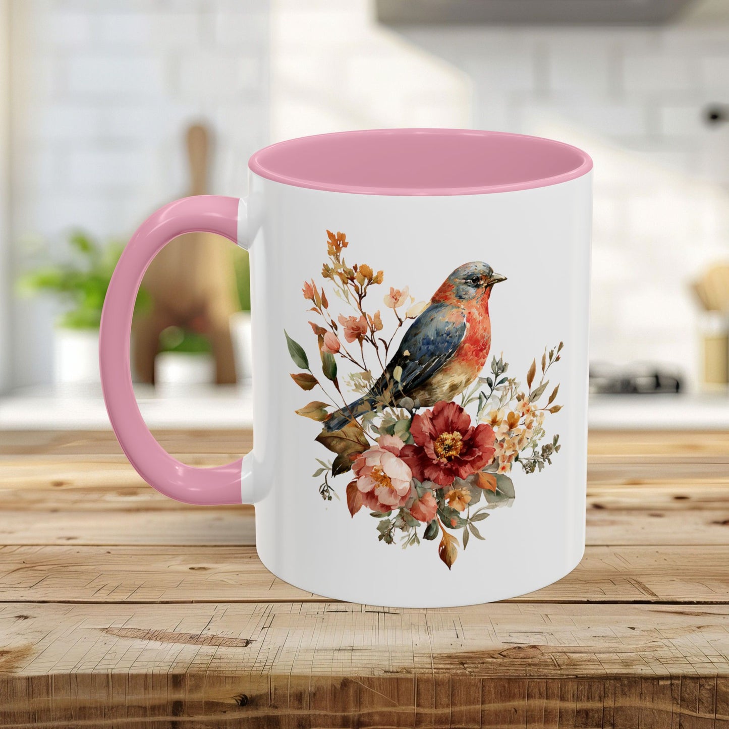 White ceramic mug with a pink interior and handle, featuring a watercolor bluebird and peony floral design.