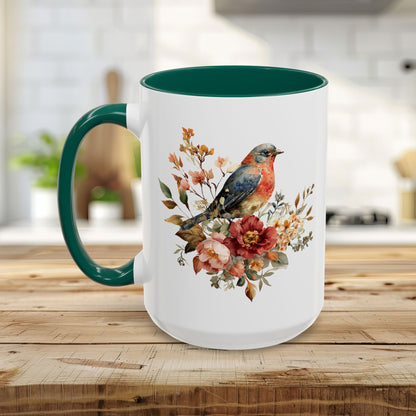 White ceramic mug with a green handle and interior, featuring a watercolor bluebird and peony floral design.