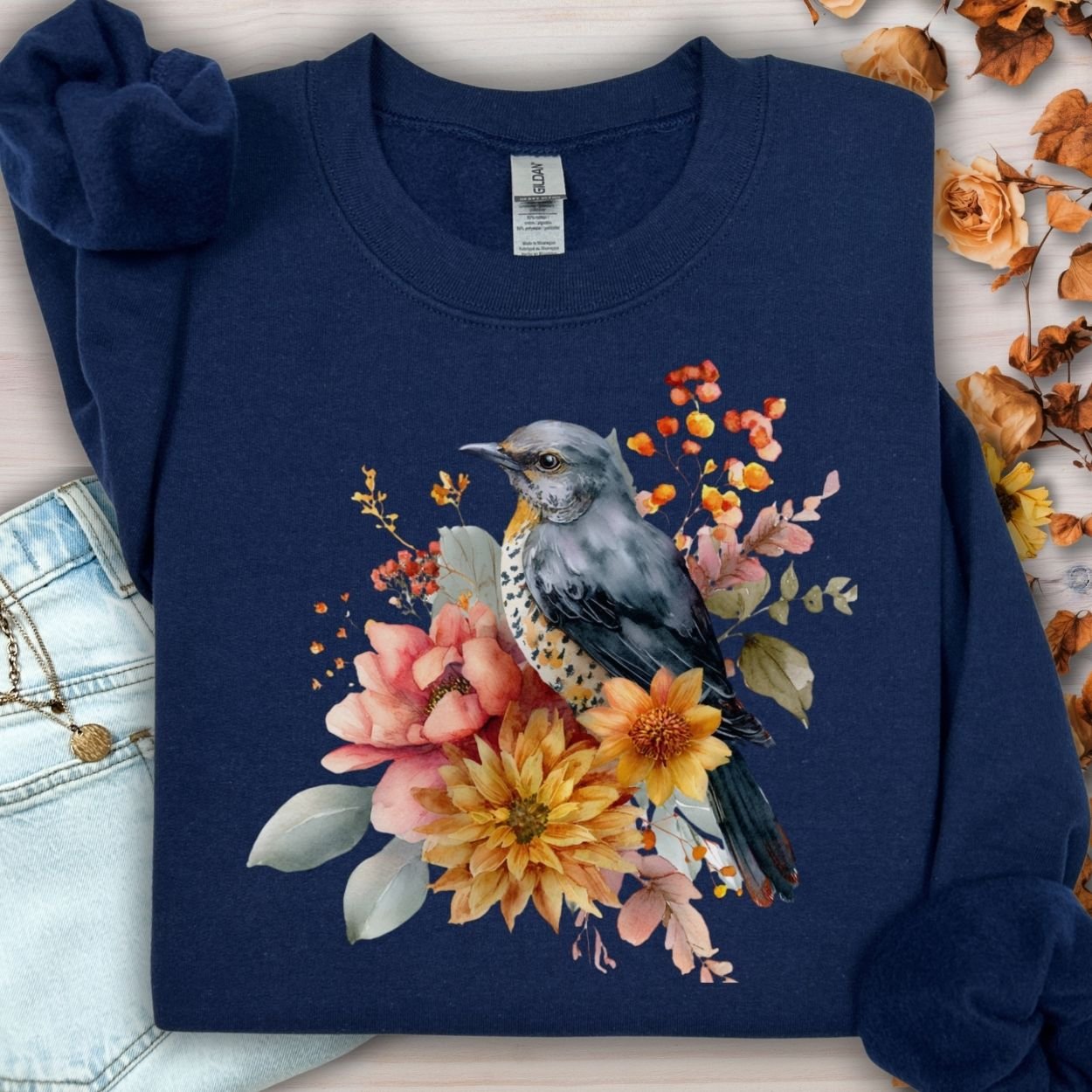 Navy crewneck sweatshirt with a painterly bluebird and autumn floral design.