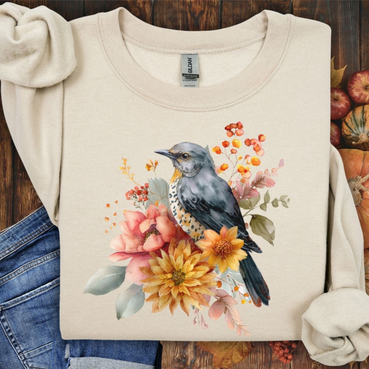 Sand crewneck sweatshirt with a painterly bluebird and autumn floral design.
