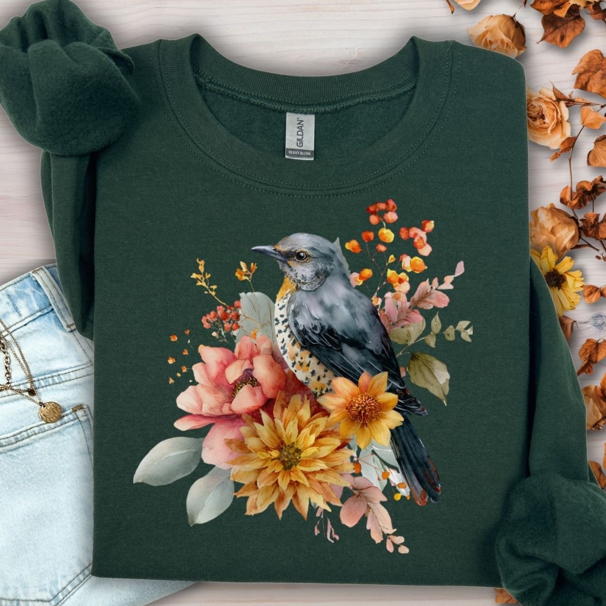 Forest green crewneck sweatshirt with a painterly bluebird and autumn floral design.
