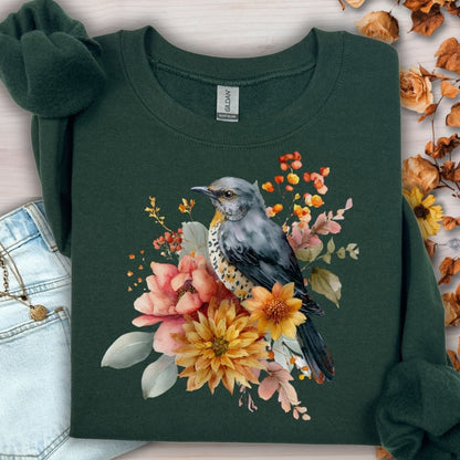 Forest green crewneck sweatshirt with a painterly bluebird and autumn floral design.