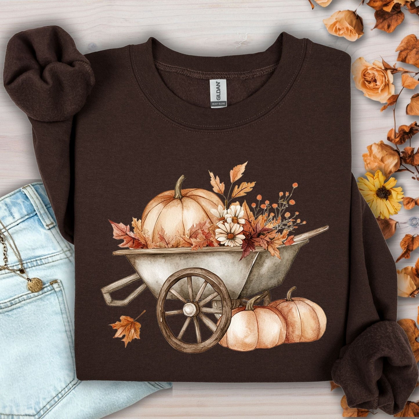 Brown Gildan sweatshirt with a boho wagon, pumpkins, and autumn flowers in muted tones.