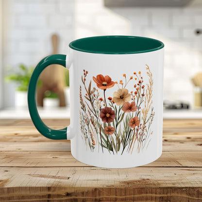 White ceramic mug with a dark green handle and interior, featuring watercolor autumn wildflowers.