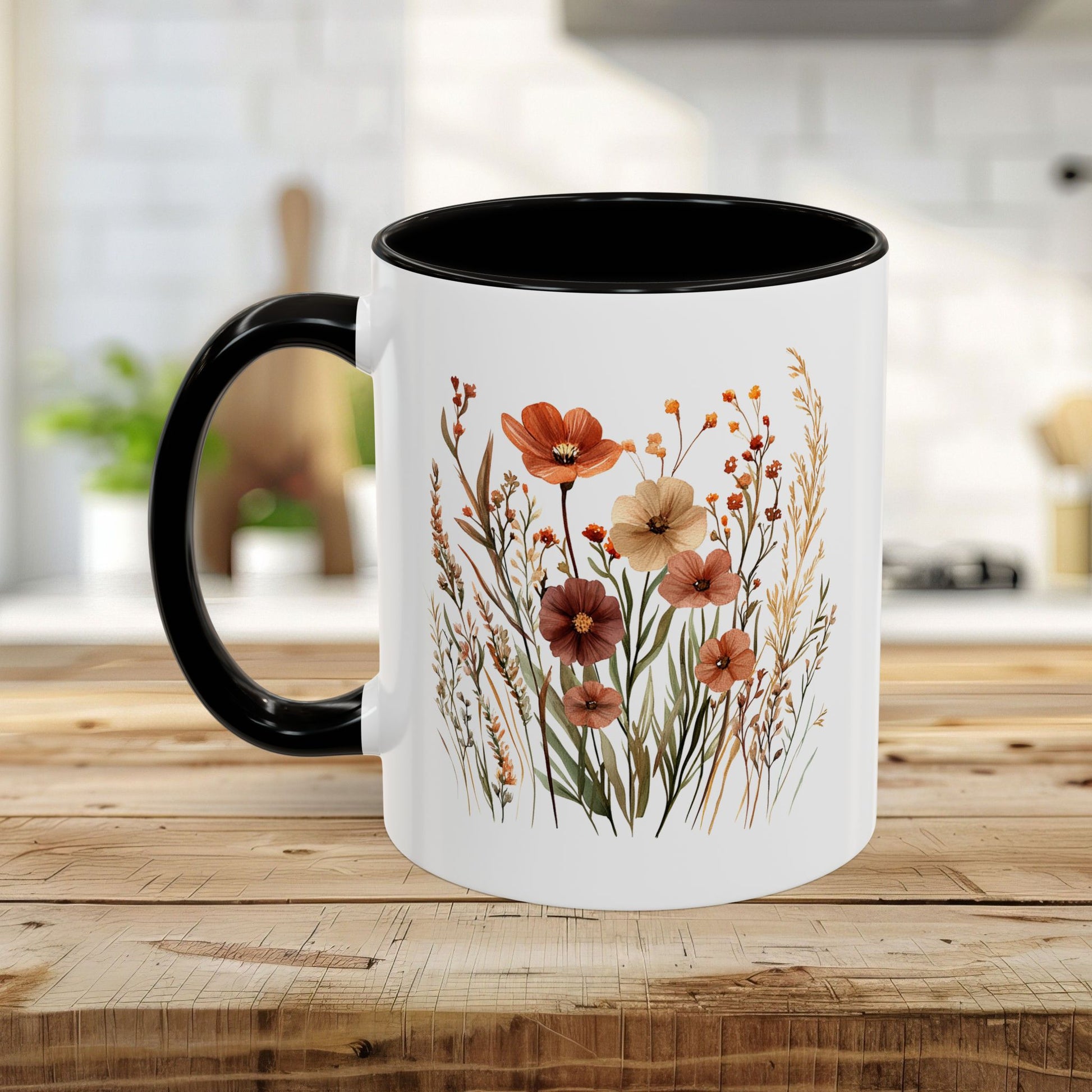 White ceramic mug with black handle and interior, featuring warm watercolor autumn wildflowers.