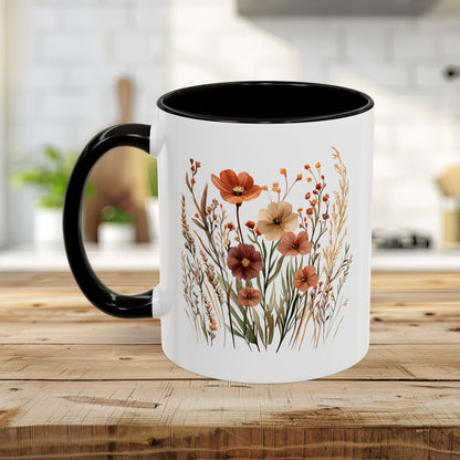 White ceramic mug with black handle and interior, featuring warm watercolor autumn wildflowers.