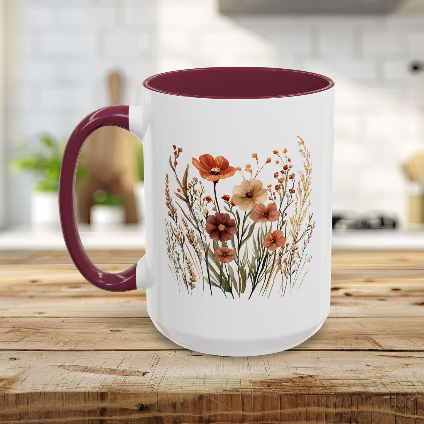 White ceramic mug with a maroon handle and interior, featuring a watercolor autumn wildflower design.