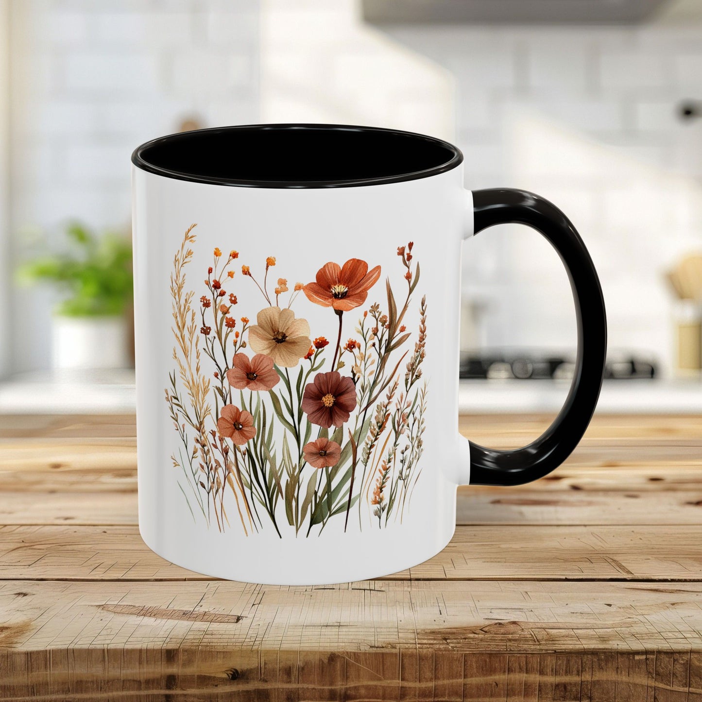 White ceramic mug with black handle and interior, featuring a watercolor autumn wildflower design.