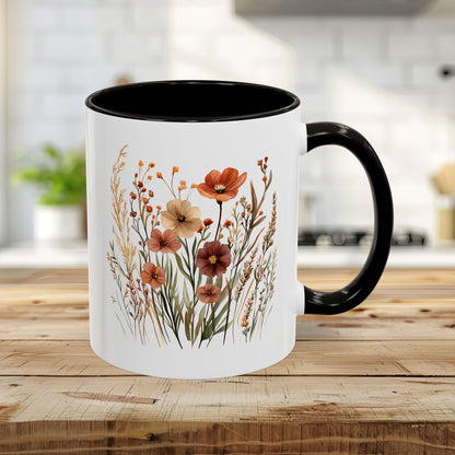 White ceramic mug with black handle and interior, featuring a watercolor autumn wildflower design.