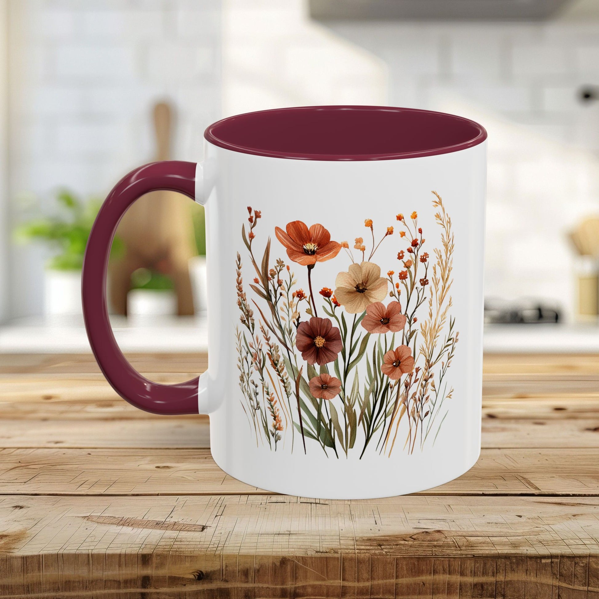 White ceramic mug with a burgundy handle and interior, featuring a watercolor autumn wildflower design.