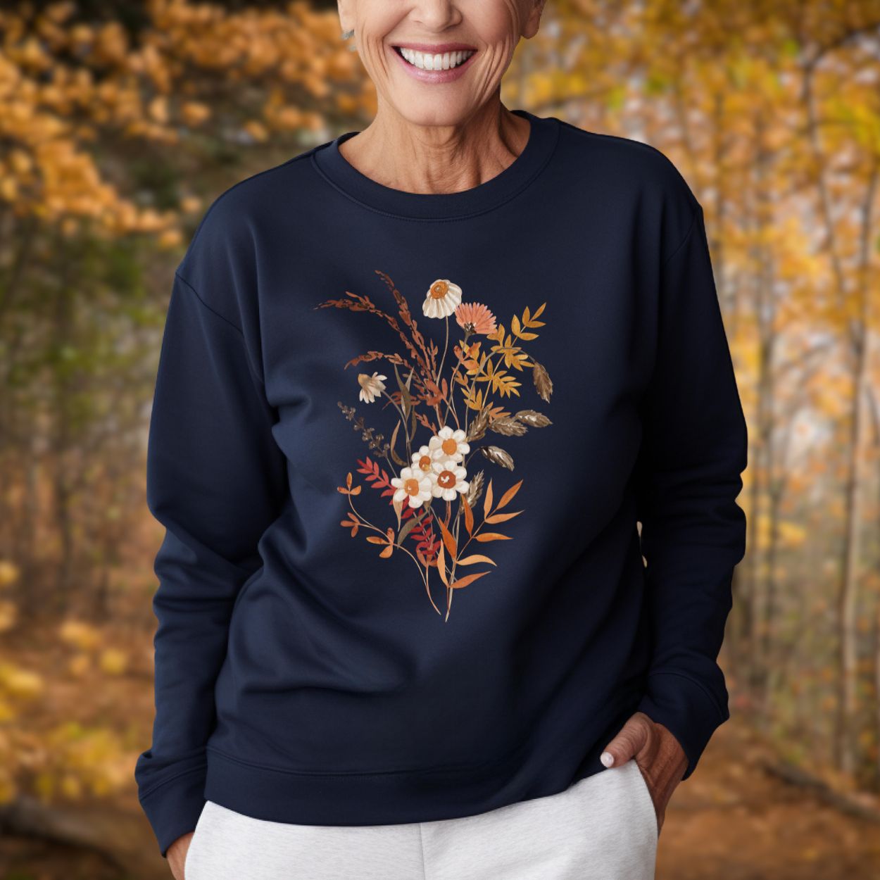 Woman in a navy botanical sweatshirt with vintage autumn wildflowers in warm beige and rust tones.
