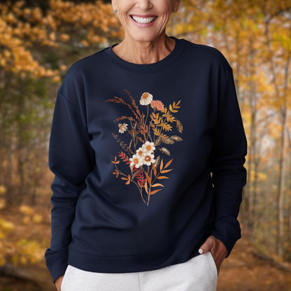 Woman in a navy botanical sweatshirt with vintage autumn wildflowers in warm beige and rust tones.