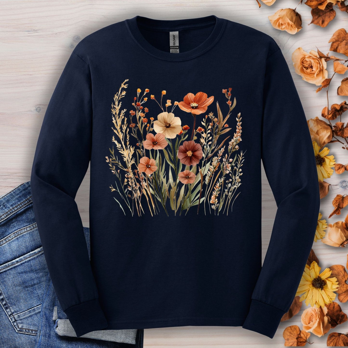 Navy long-sleeve cotton tee with watercolor autumn wildflowers in warm, earthy hues.
