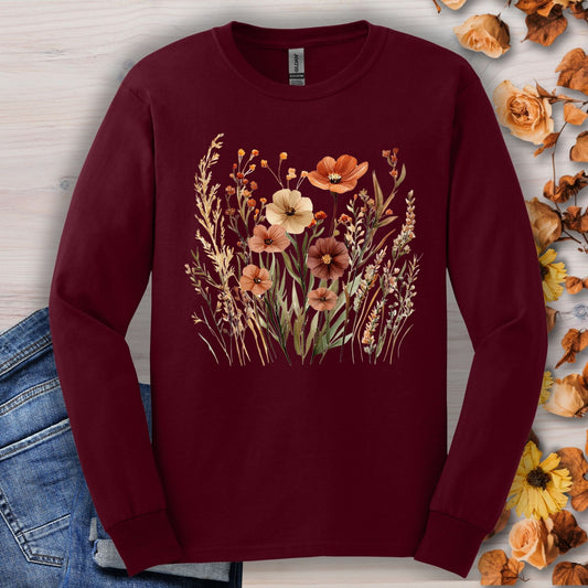 Maroon long-sleeve tee with watercolor autumn wildflowers, shown with jeans and fall leaves.