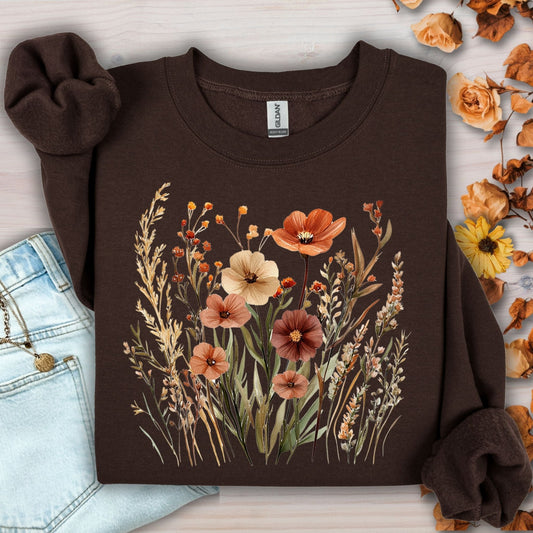Dark chocolate Gildan cotton-blend sweatshirt with watercolor autumn wildflowers and poppies, next to jeans.