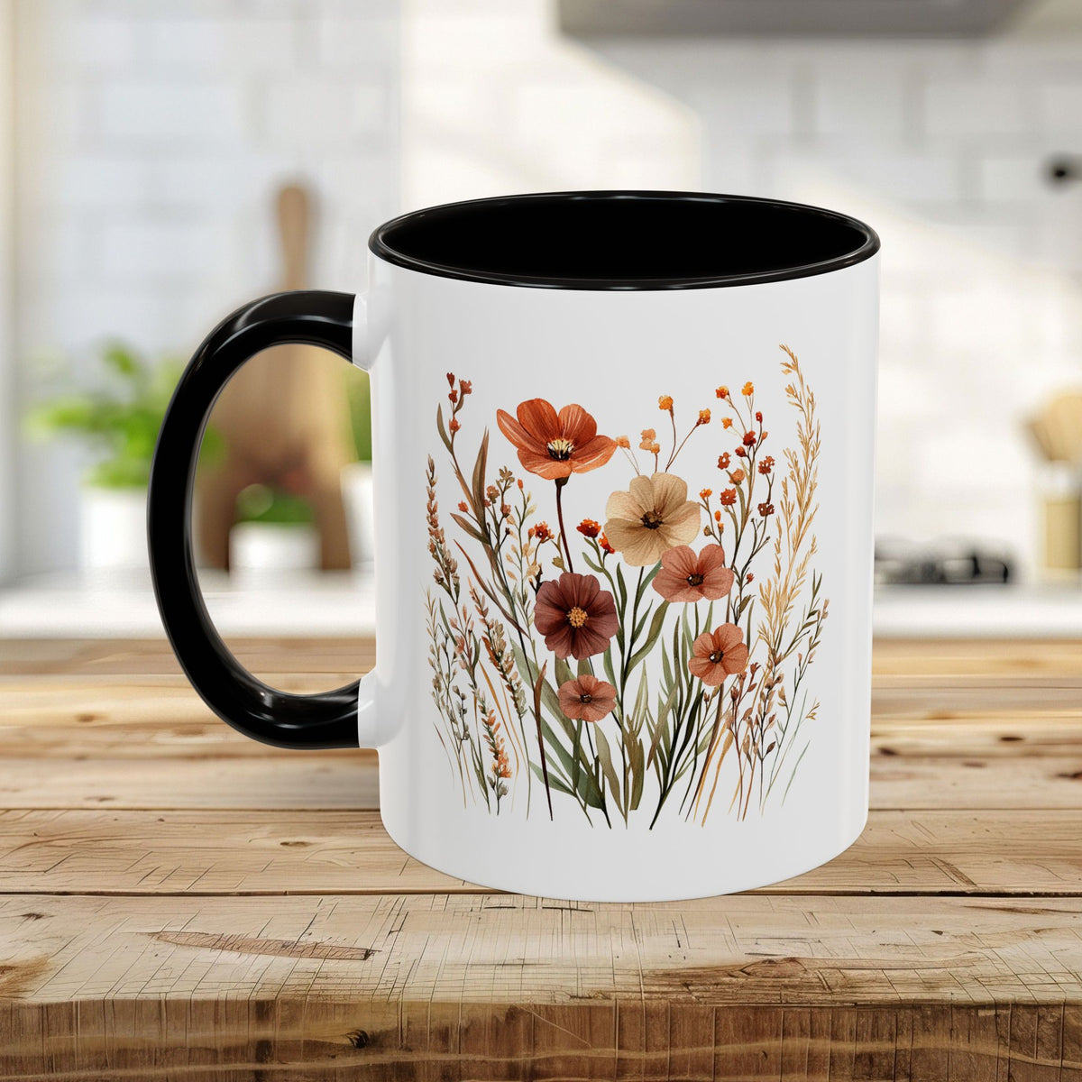 White ceramic mug with black handle and interior, featuring warm watercolor autumn wildflowers.
