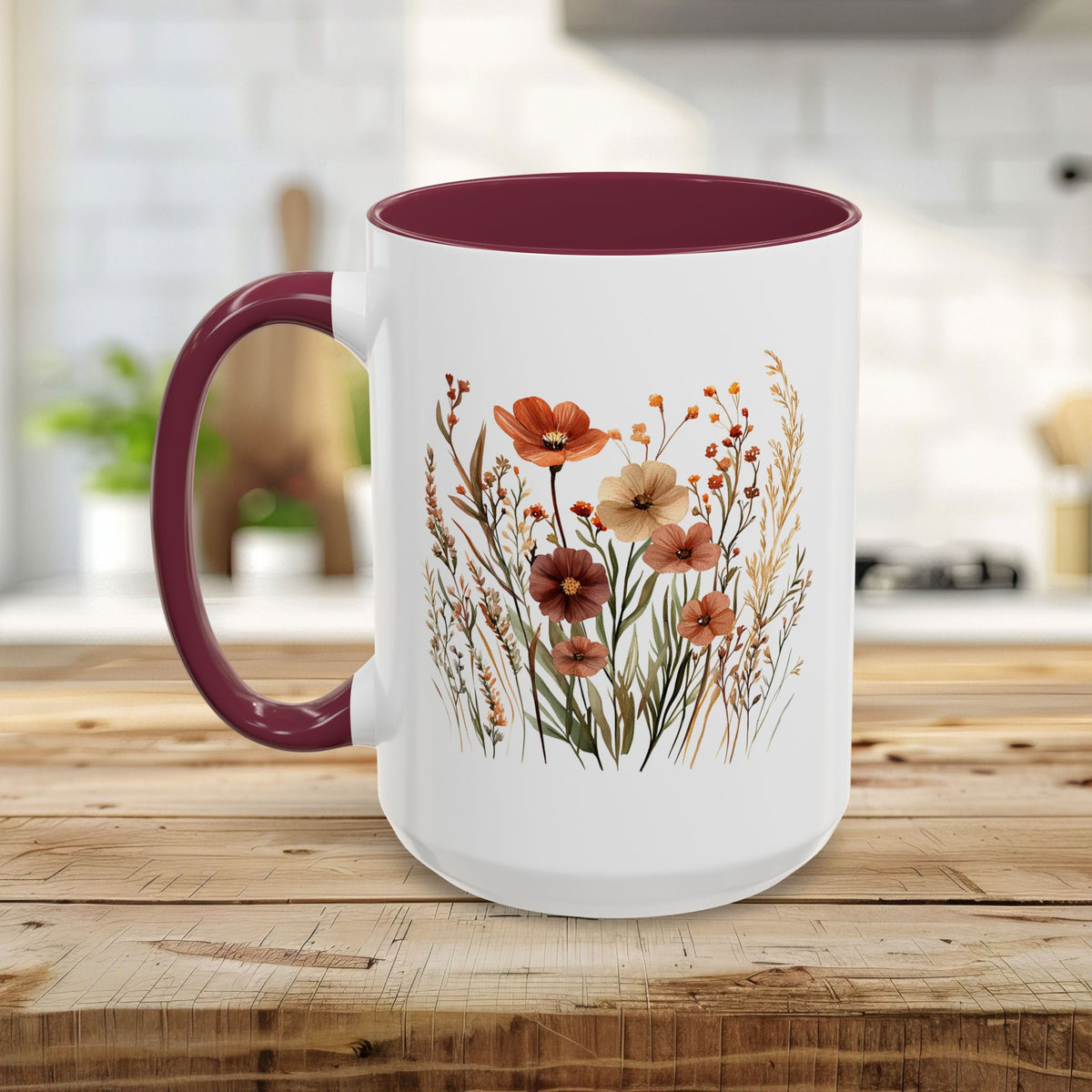 White ceramic mug with a maroon handle and interior, featuring a watercolor autumn wildflower design.