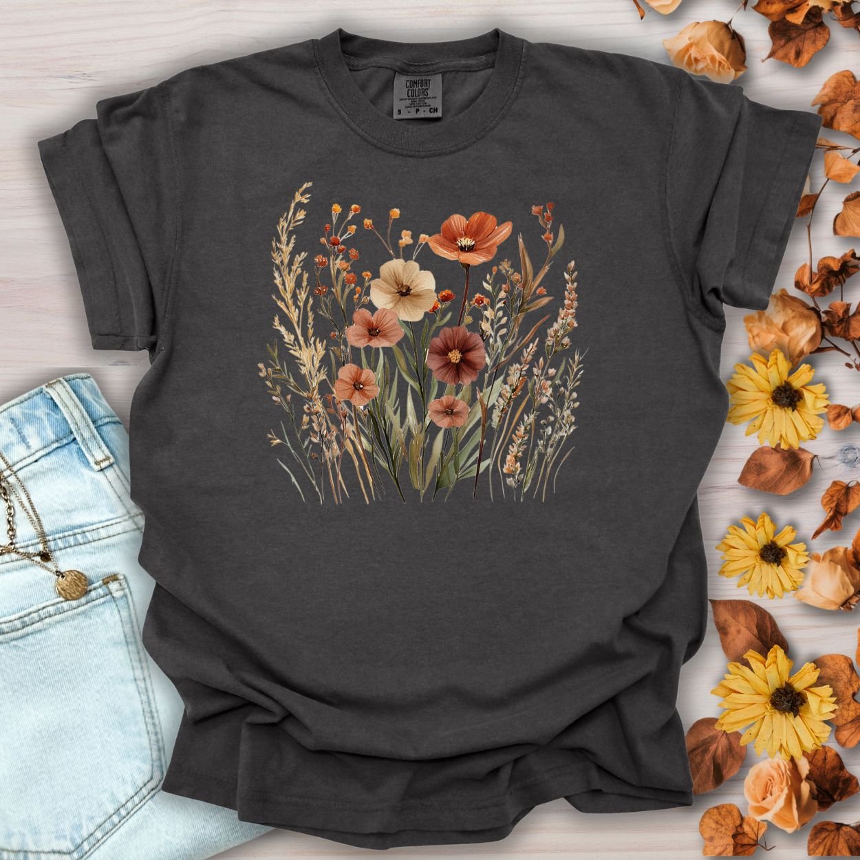 Pepper-colored cotton t-shirt with a watercolor autumn wildflower design in rust, ochre, and plum.