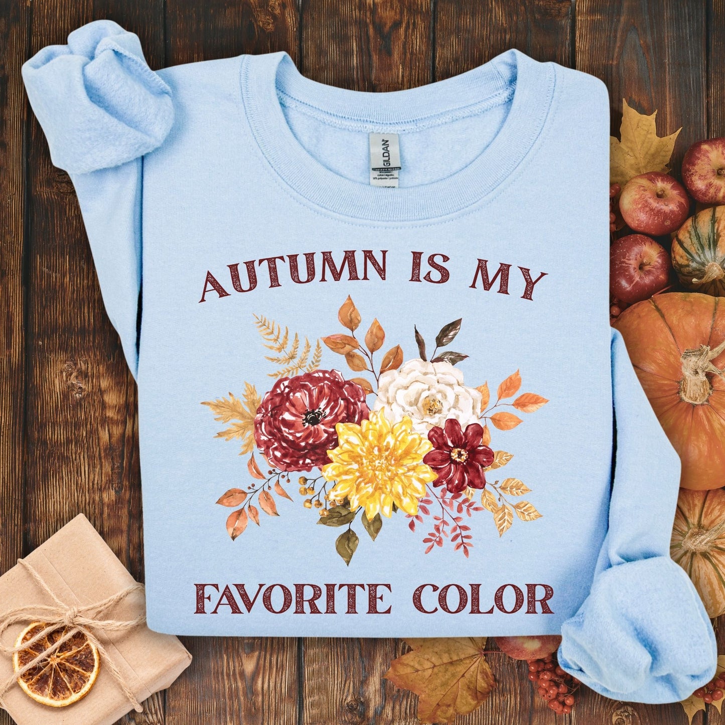 Light blue Gildan sweatshirt with "Autumn is My Favorite Color" text and watercolor fall flowers.