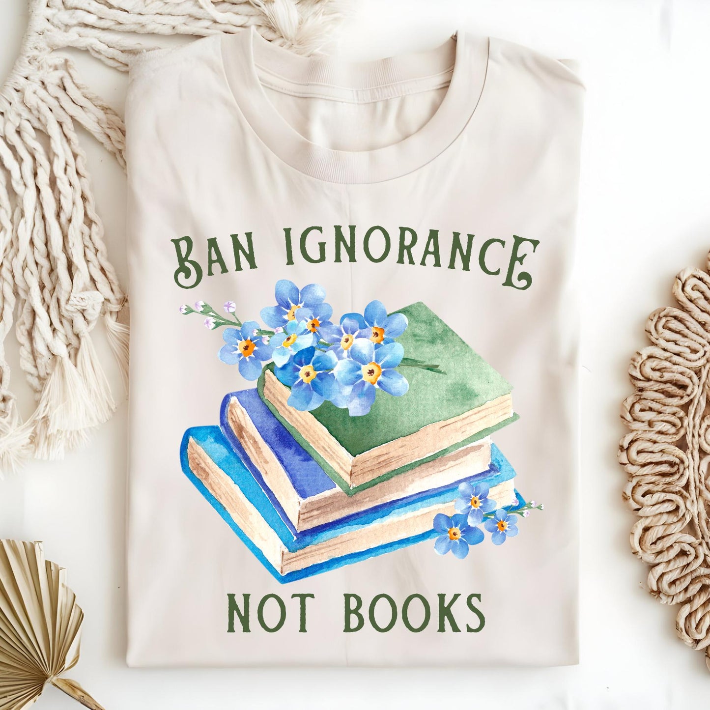 Natural S t-shirt with "Ban Ignorance, Not Books" text, vintage books, and blue forget-me-nots.