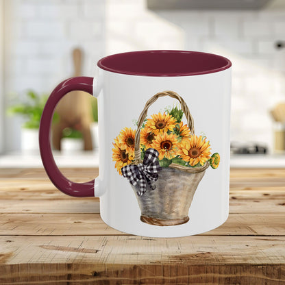 White ceramic mug with a burgundy handle and interior, featuring a watercolor basket of sunflowers and a gingham bow.