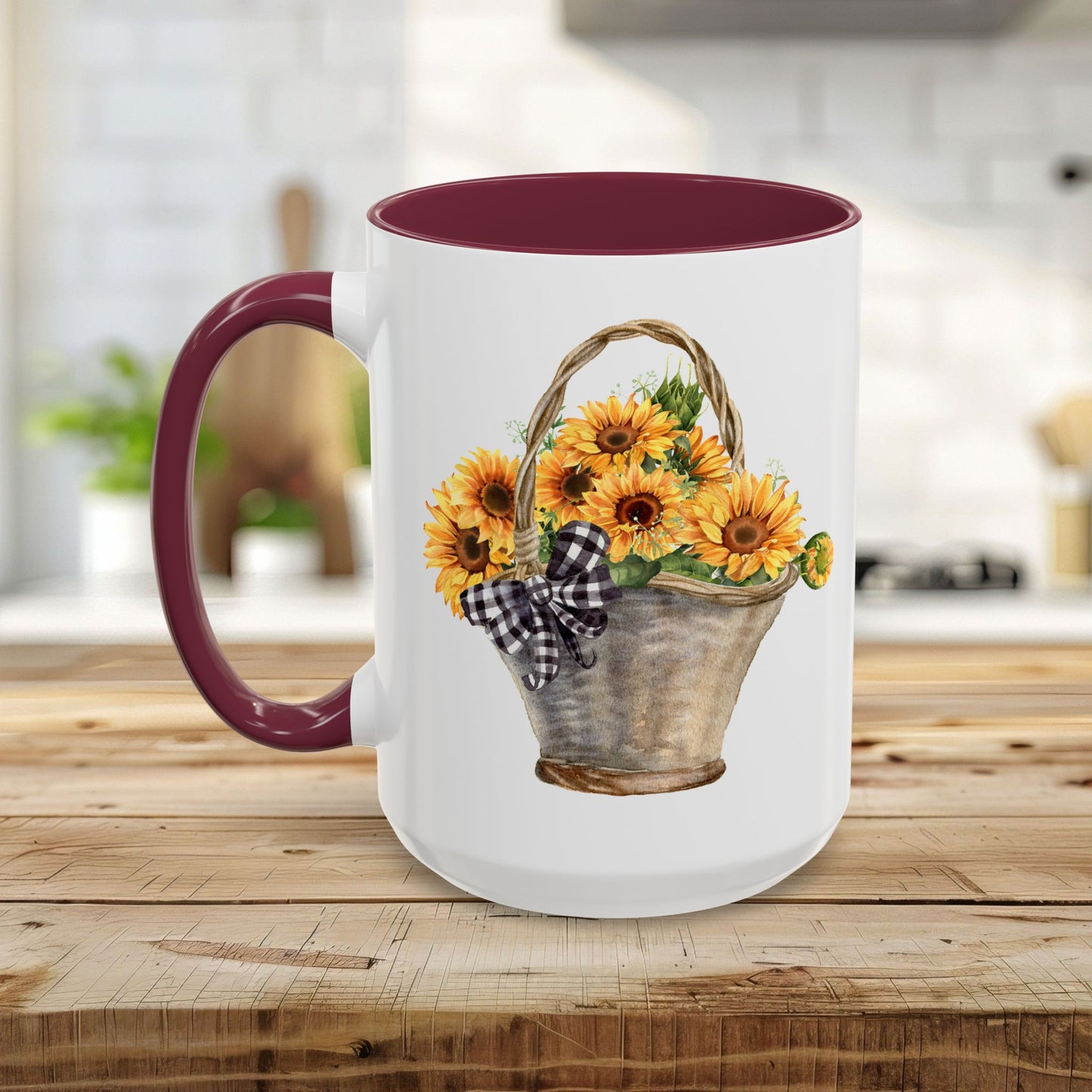 White ceramic mug with a maroon handle and interior, featuring a watercolor basket of sunflowers and a gingham bow.