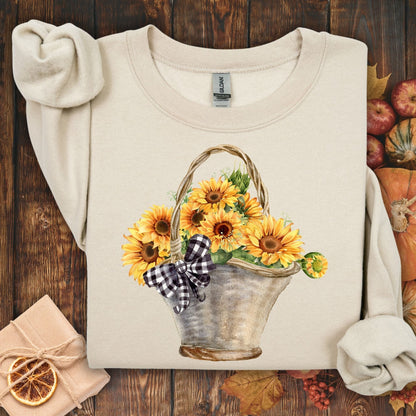 Sand Gildan crewneck sweatshirt with a watercolor basket of sunflowers and a black-and-white checkered bow.