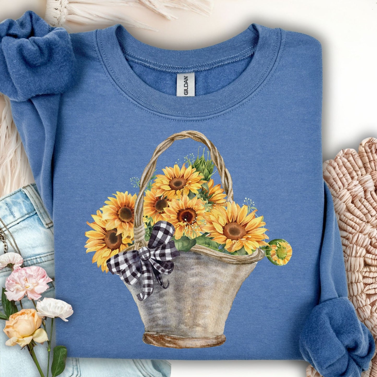 Indigo blue sweatshirt with a watercolor basket of sunflowers and a black-and-white checkered bow.