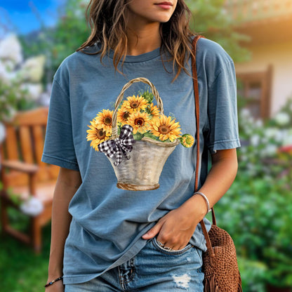 Relaxed-fit, garment-dyed blue cotton t-shirt with a hand-painted basket of sunflowers and gingham bow.