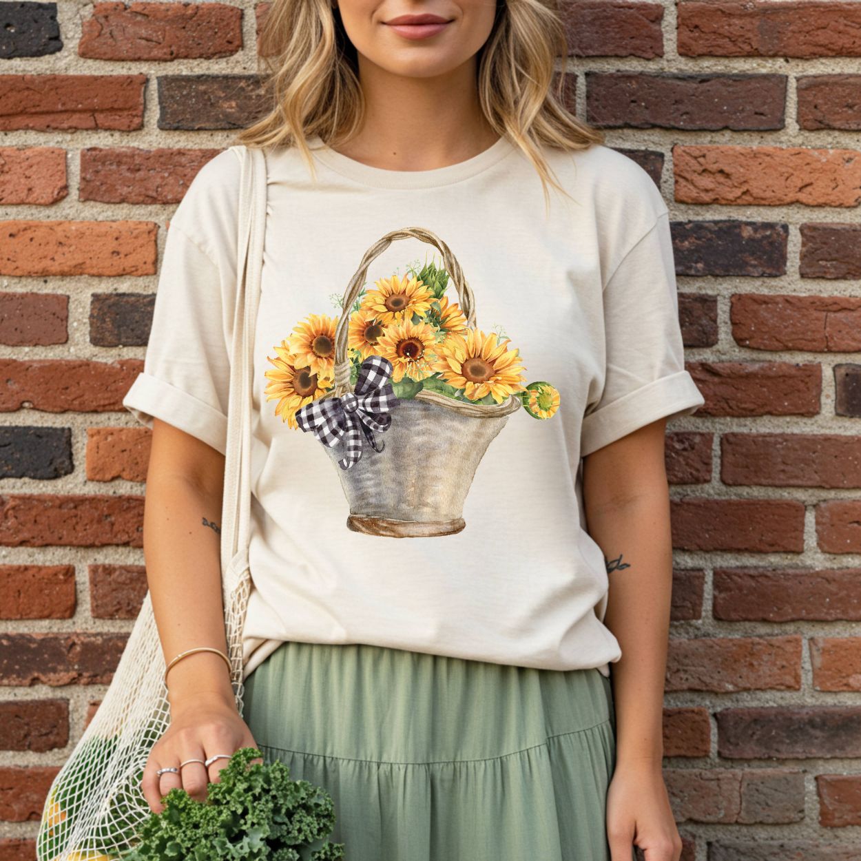 Relaxed-fit, garment-dyed cream t-shirt with a watercolor basket of sunflowers and a gingham bow.