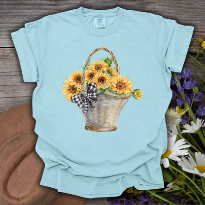 Chambray blue garment-dyed t-shirt with a watercolor basket of sunflowers and a gingham bow.