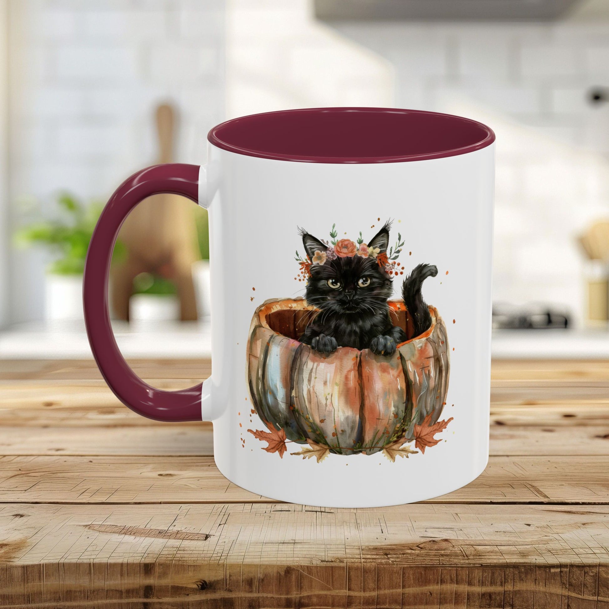 White ceramic mug with a maroon handle and interior, featuring a watercolor black kitten in a pumpkin.