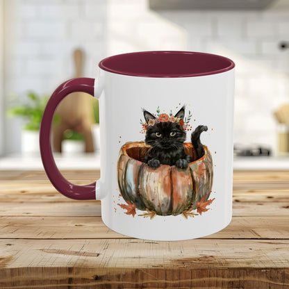 White ceramic mug with a maroon handle and interior, featuring a watercolor black kitten in a pumpkin.