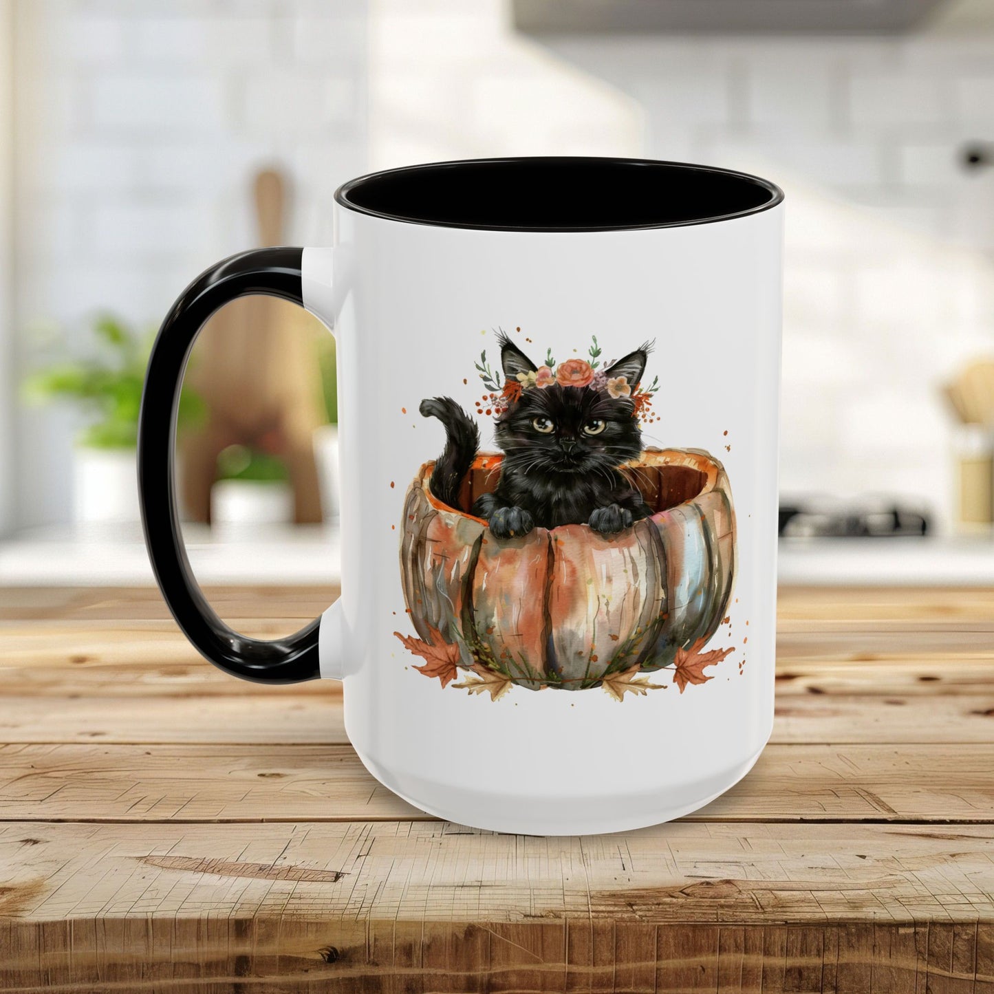 White ceramic mug with black handle and interior, featuring a watercolor black kitten in a pumpkin with fall leaves.