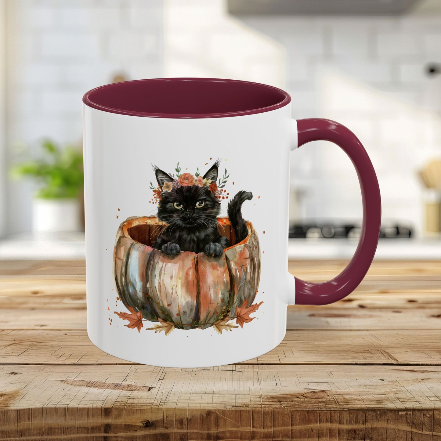 White ceramic mug with maroon handle and interior, featuring a watercolor black kitten in a pumpkin.