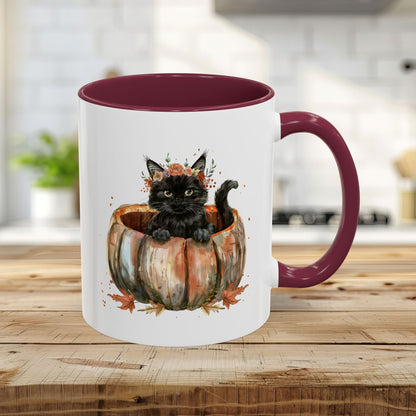 White ceramic mug with maroon handle and interior, featuring a watercolor black kitten in a pumpkin.