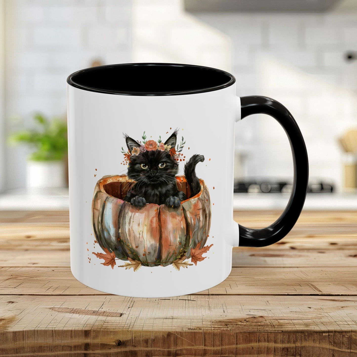 White ceramic 11oz mug with black interior/handle, featuring a watercolor black kitten in a pumpkin with fall leaves.