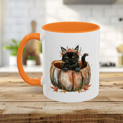 White ceramic mug with orange handle and interior, featuring a watercolor black kitten in a pumpkin.