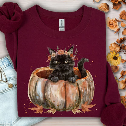 Maroon Gildan sweatshirt with a watercolor black cat in a pumpkin and autumn flowers.