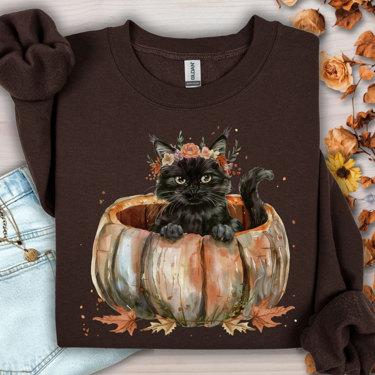 Dark chocolate Gildan sweatshirt with a watercolor black cat in a pumpkin surrounded by fall flowers.