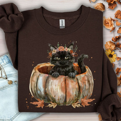 Dark chocolate Gildan sweatshirt with a watercolor black cat in a pumpkin surrounded by fall flowers.