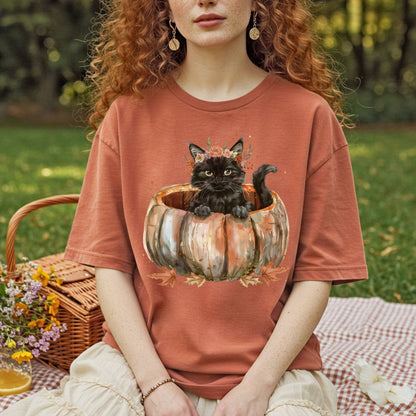 Comfort Colors t-shirt with watercolor black cat in pumpkin, surrounded by autumn flowers.