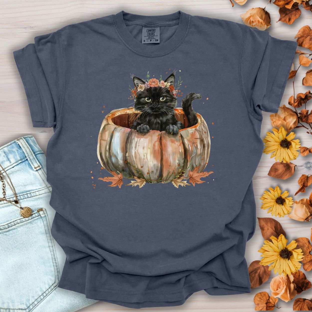 Denim Comfort Colors t-shirt with a watercolor black cat in a pumpkin surrounded by autumn flowers.