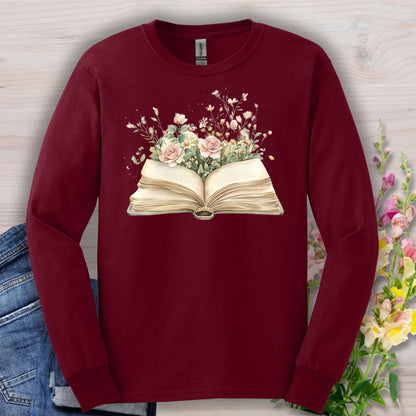Maroon long sleeve tee with an open vintage book illustration blooming with watercolor roses and wildflowers.