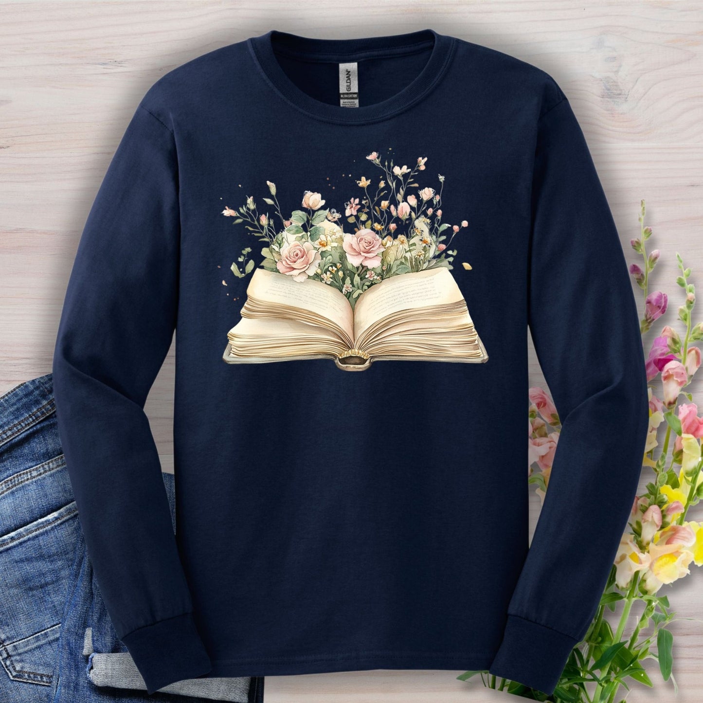 Navy long sleeve tee with an open vintage book design blooming with watercolor roses and wildflowers.